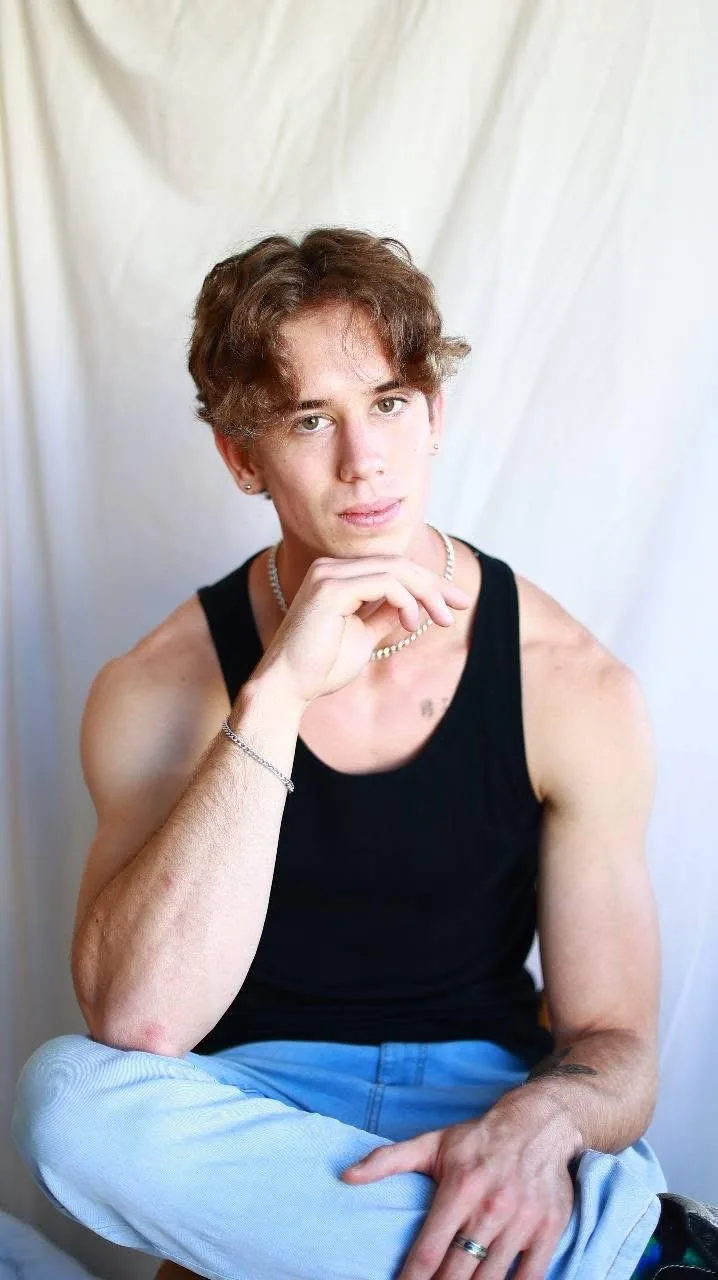 Sam Frankel in a black shirt, thoughtful and focused as a personal coach.